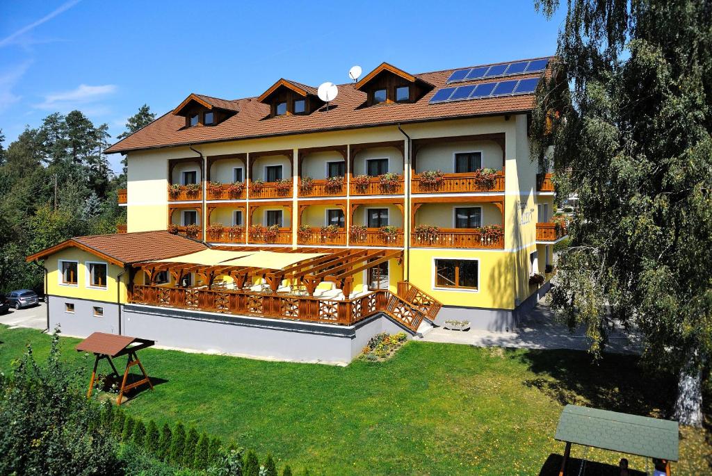 圣卡尼兹亚历克斯酒店的一座大型黄色建筑,上面有太阳能电池板