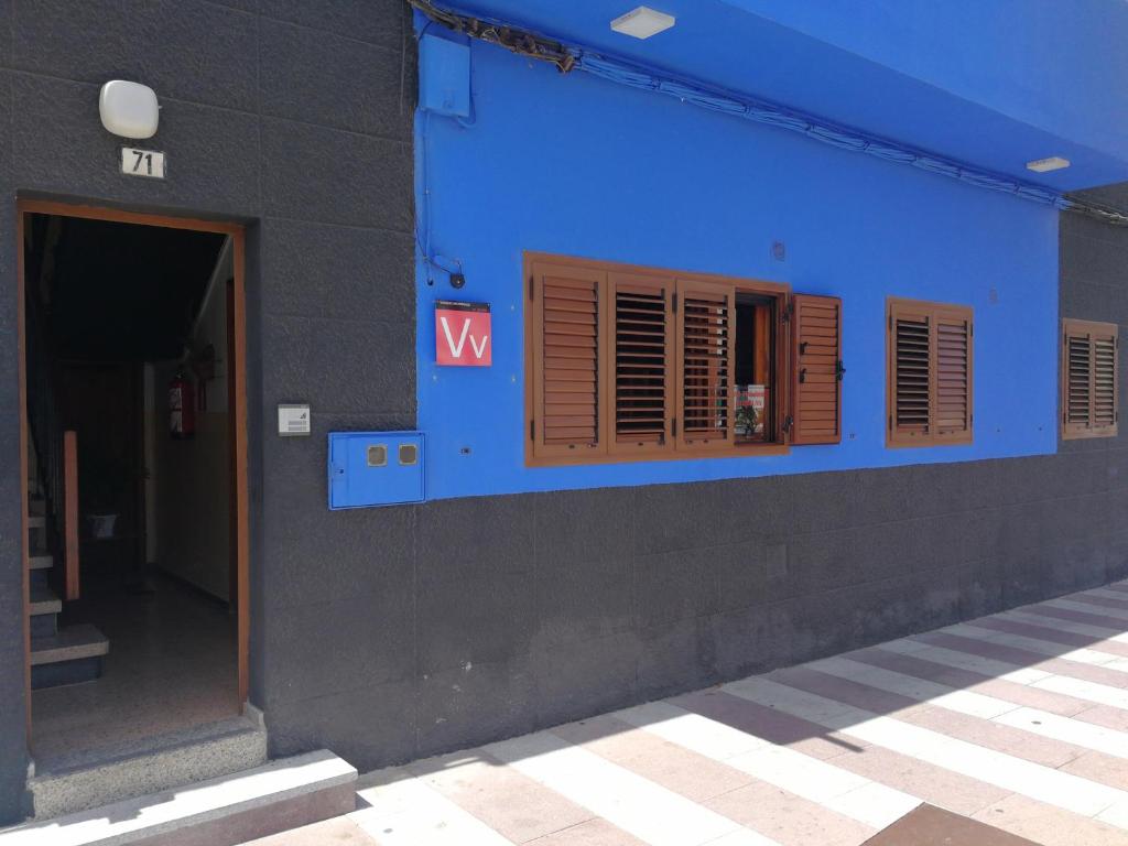 阿里纳加Casa Mar Azul的蓝色的建筑,有棕色百叶窗和标志