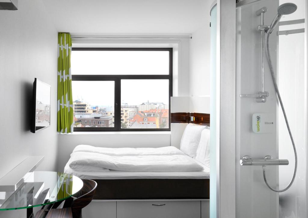 奥胡斯Wakeup - Aarhus的一间小卧室,配有床和窗户