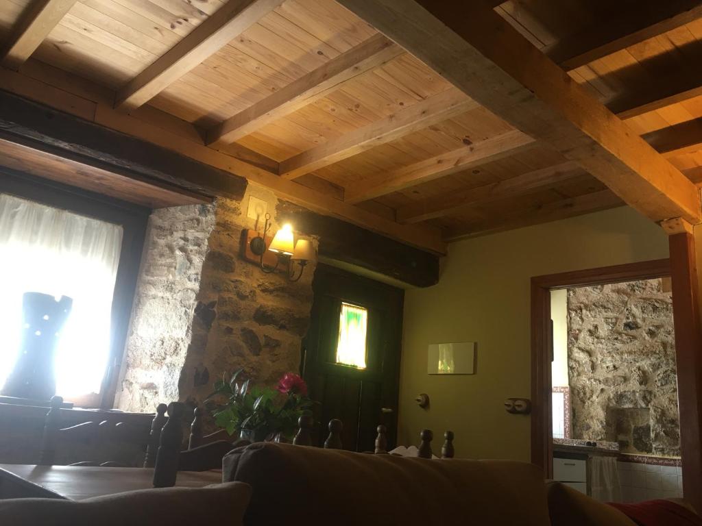 Linares de Riofrío卡萨吉姆莫里森农家度假屋的客厅设有木制天花板和石墙