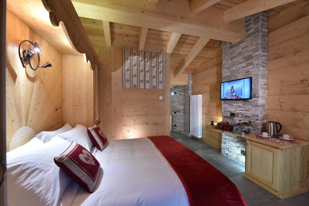 布勒伊-切尔维尼亚Il Cuore Del Cervino的一间带一张大床的卧室,位于带木墙的房间