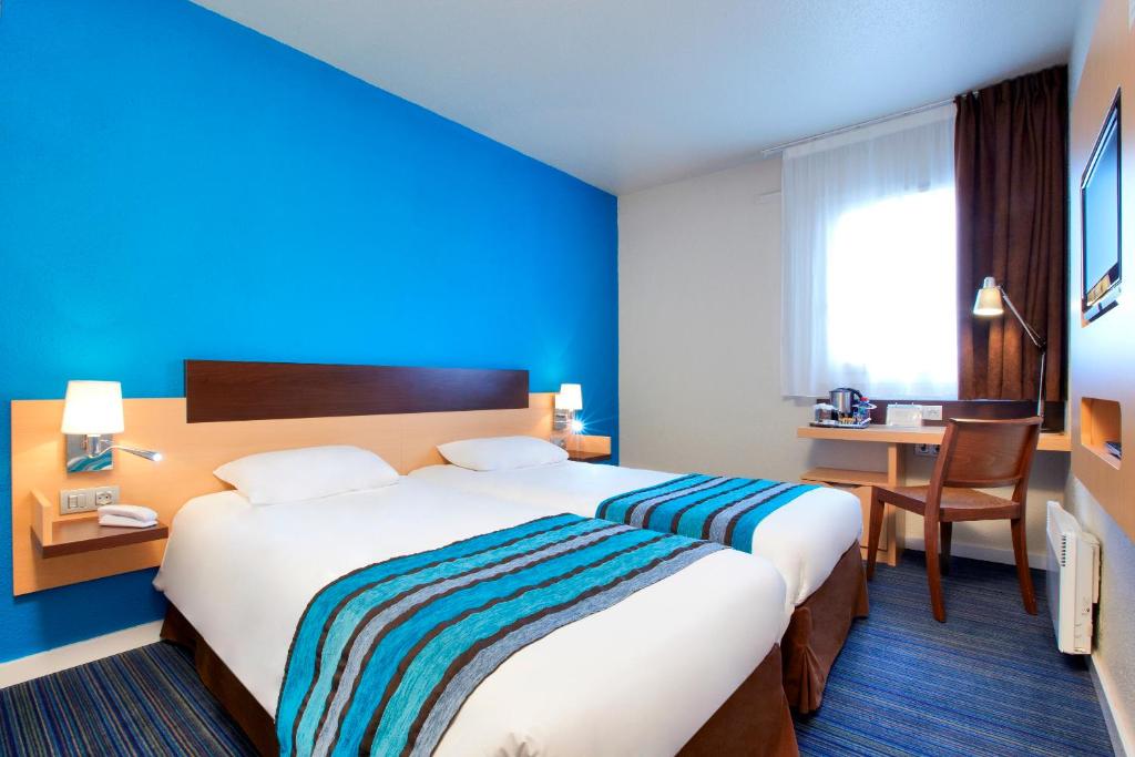 维里沙蒂隆基里亚德威利查狄龙酒店的酒店客房设有一张大床和一张书桌。