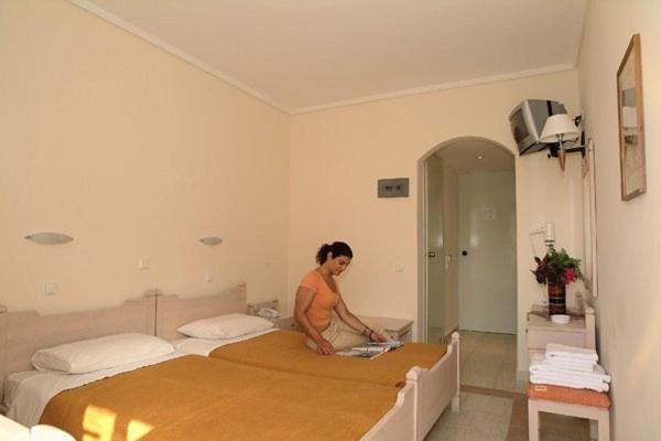 科斯镇赛奥妮亚酒店的站在房间里床边的女人