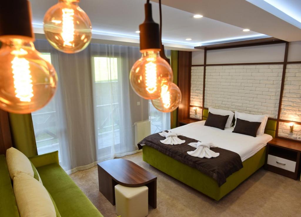 班斯科Green Life Boutique Apartments的一间卧室配有床、沙发和灯。