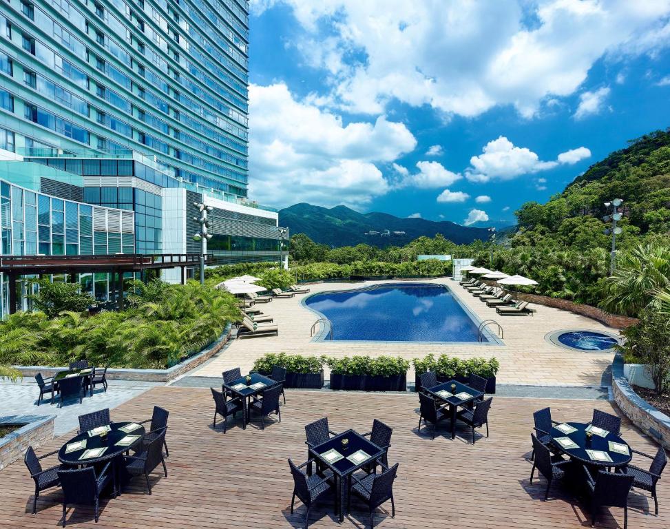 香港香港沙田凯悦酒店的一个带椅子的庭院、一个游泳池和一座建筑