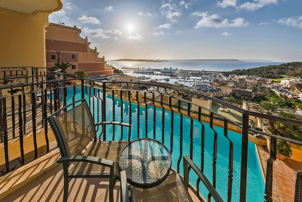 艾因西莱姆戈佐大酒店的阳台配有两把椅子,享有海景。