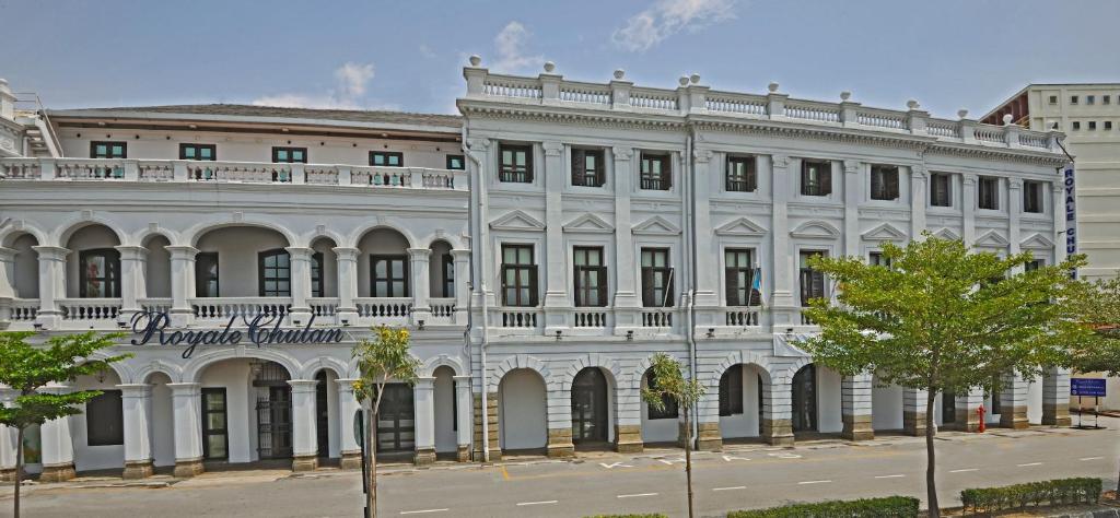 乔治市槟城皇家朱兰酒店的一座白色的大建筑,有很多窗户