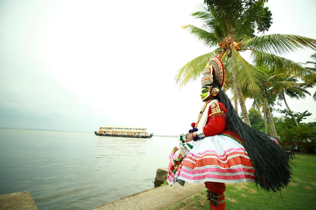 阿勒皮Southern Panorama Houseboats的站在水体旁边的女装