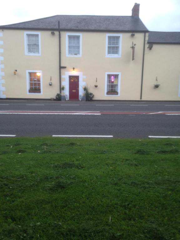 卡莱尔Lynebank House Hotel, Bed & Breakfast的街上有红色门的白色房子