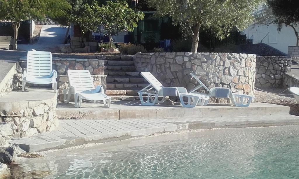 斯顿Kuća za odmor >Maro<的一组椅子坐在水池边