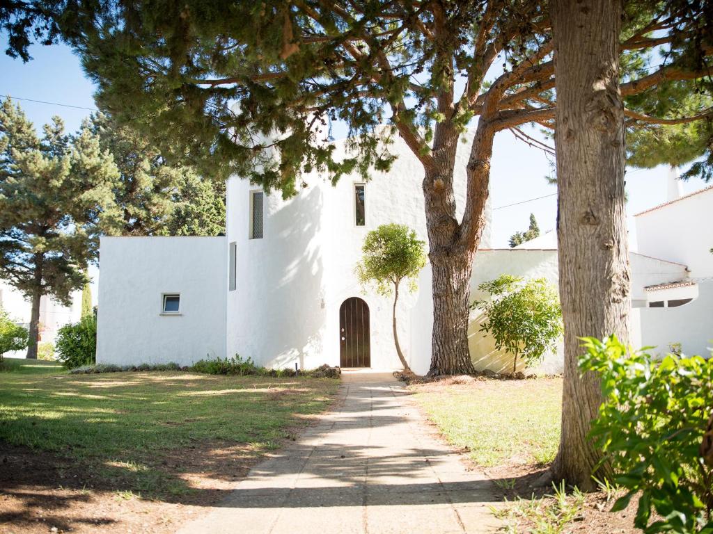 珀彻斯Vivenda Jardim Mar Algarve Porches的前面有棵树的白色建筑