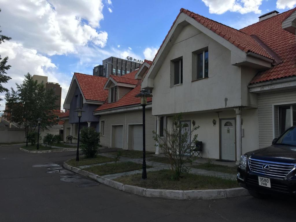 乌兰巴托T house的街道上一排房子,有一辆汽车停放