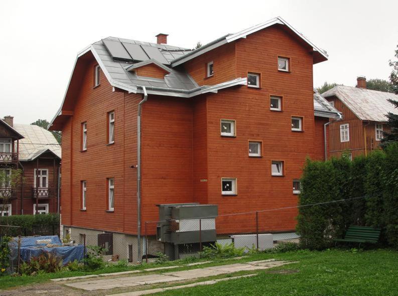 伊沃尼奇-兹德鲁伊Hostel Promyk的一座带金属屋顶的大型棕色建筑