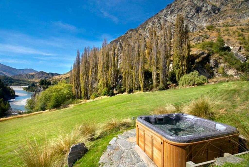 皇后镇峡谷住宿加早餐旅馆的一座位于草地山顶的热水浴池