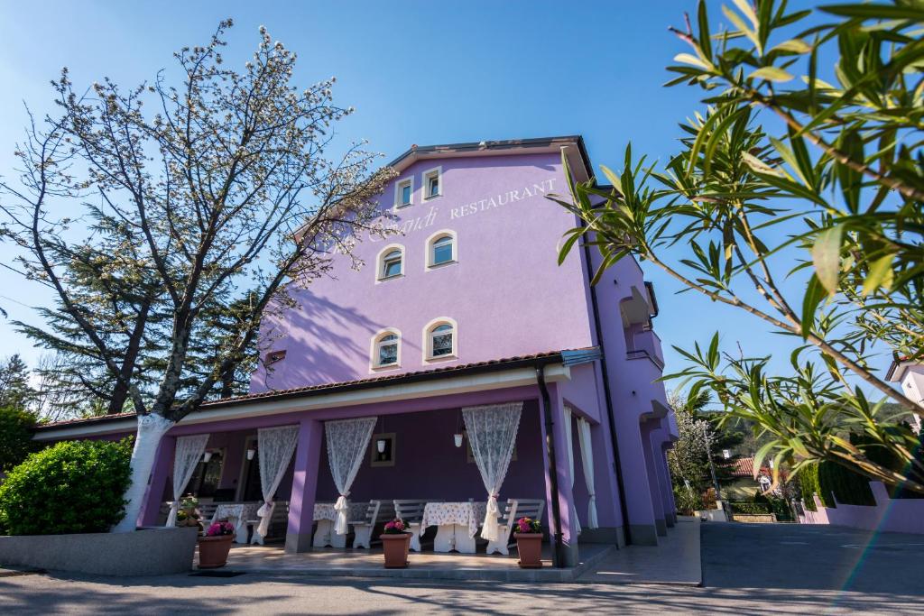 卡维勒Hotel Villa Sandi - free parking的一座紫色的建筑,前面有树木