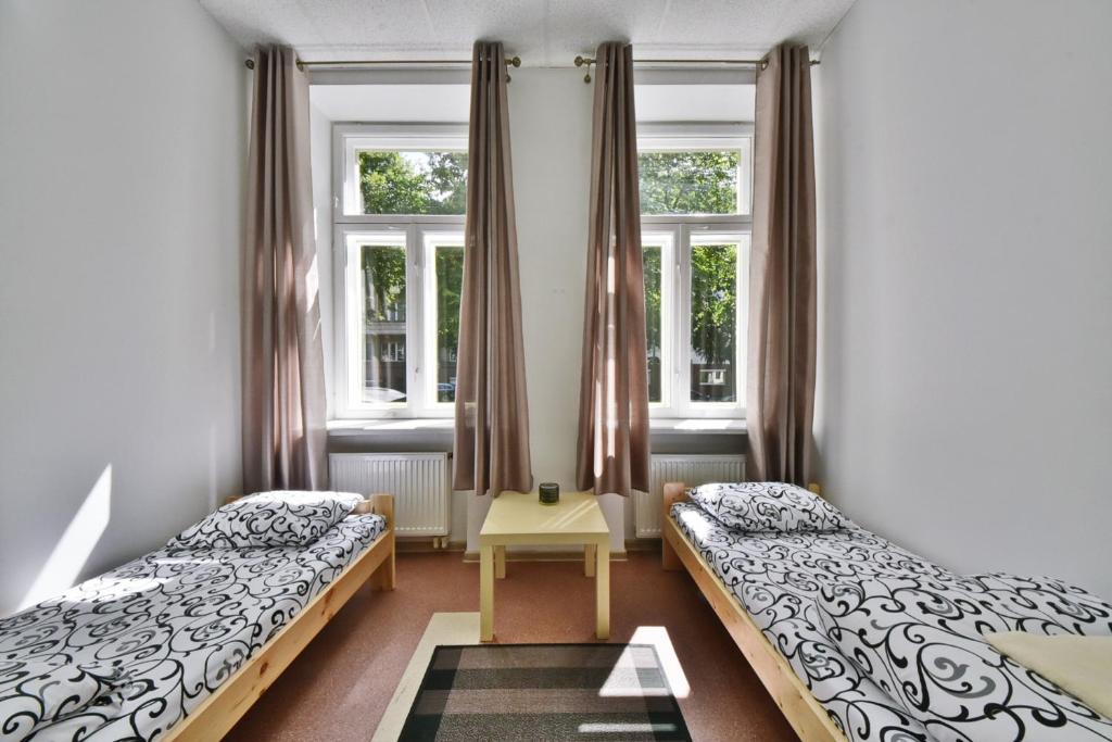 考纳斯Laisves Avenue Hostel "Easy Kaunas"的一间卧室设有两张床和两个窗户。