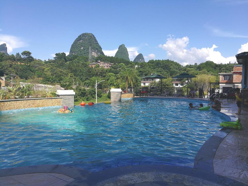 阳朔阳朔边城漓谷度假山庄的一群人在一座山地游泳池游泳