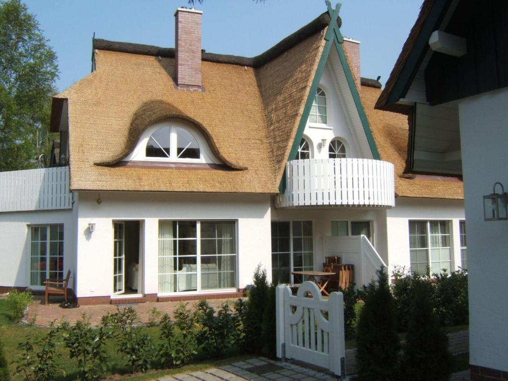 青斯特Zingst-3-Zi-Ferienwohnung-SEELORD-Strandresidenz-Godeke-Michels的白色房子,有棕色的屋顶