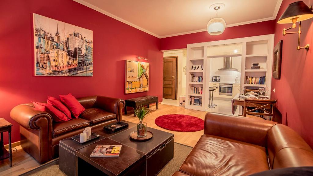 塞萨洛尼基Elegant Supercentral Apartment的客厅设有红色的墙壁和皮革家具