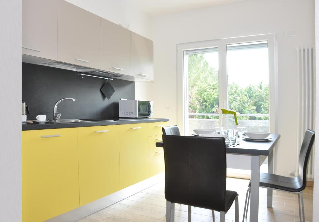 阿科Easy & Modern的厨房配有黄色橱柜和桌椅