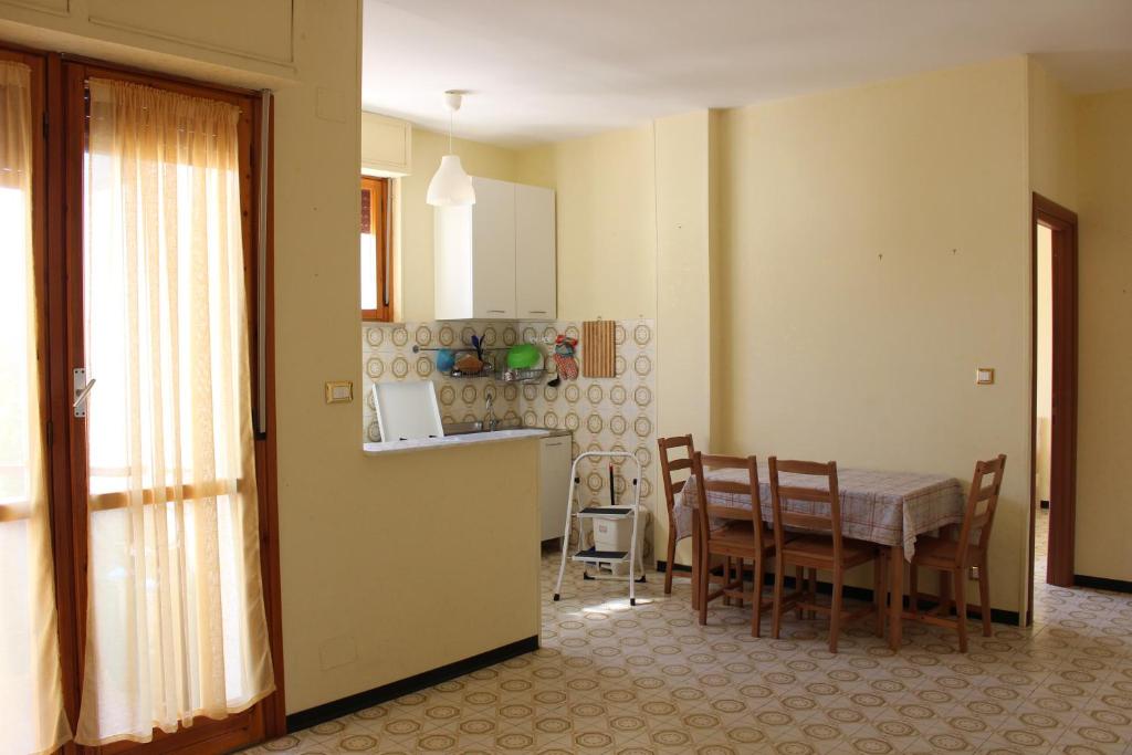 坎波马里诺Appartamento Ciclamini的厨房以及带桌椅的用餐室。