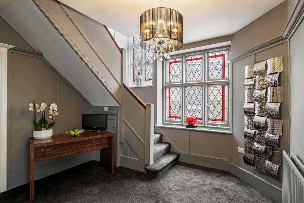伦敦M - 霍特尔斯公寓的走廊设有楼梯、吊灯和书桌