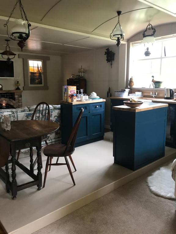 阿马Log cabin的厨房配有蓝色橱柜和桌椅