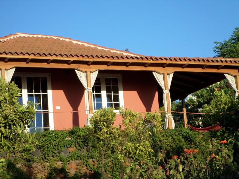 蓬塔戈尔达Casa Bellavista的红色的房子,有屋顶和灌木丛