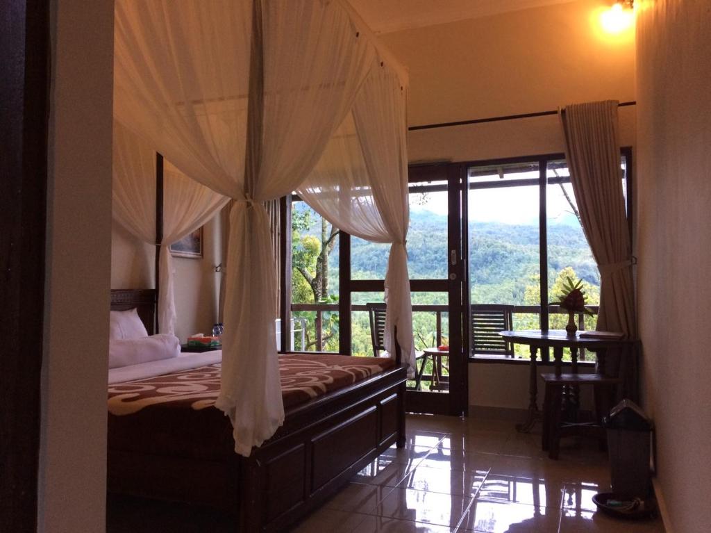 姆杜克梅德奥卡寄宿宾馆和商店的一间卧室设有一张天蓬床,享有美景。