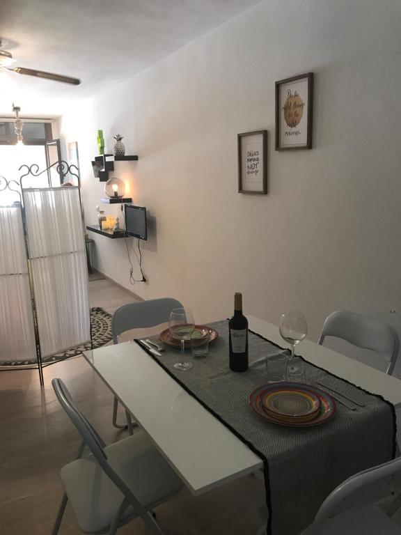 厄尔梅达诺Las Olas的用餐室配有带1瓶葡萄酒的桌子