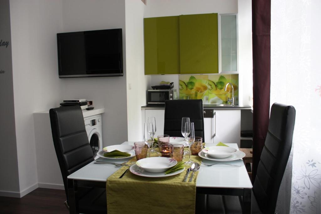 维也纳佐维娜酒店 - 市中心公寓的用餐室配有带盘子和玻璃杯的桌子