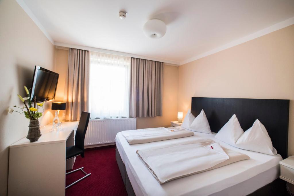 菲拉赫Stadthotel Kramer的酒店客房设有一张大床和一张书桌。