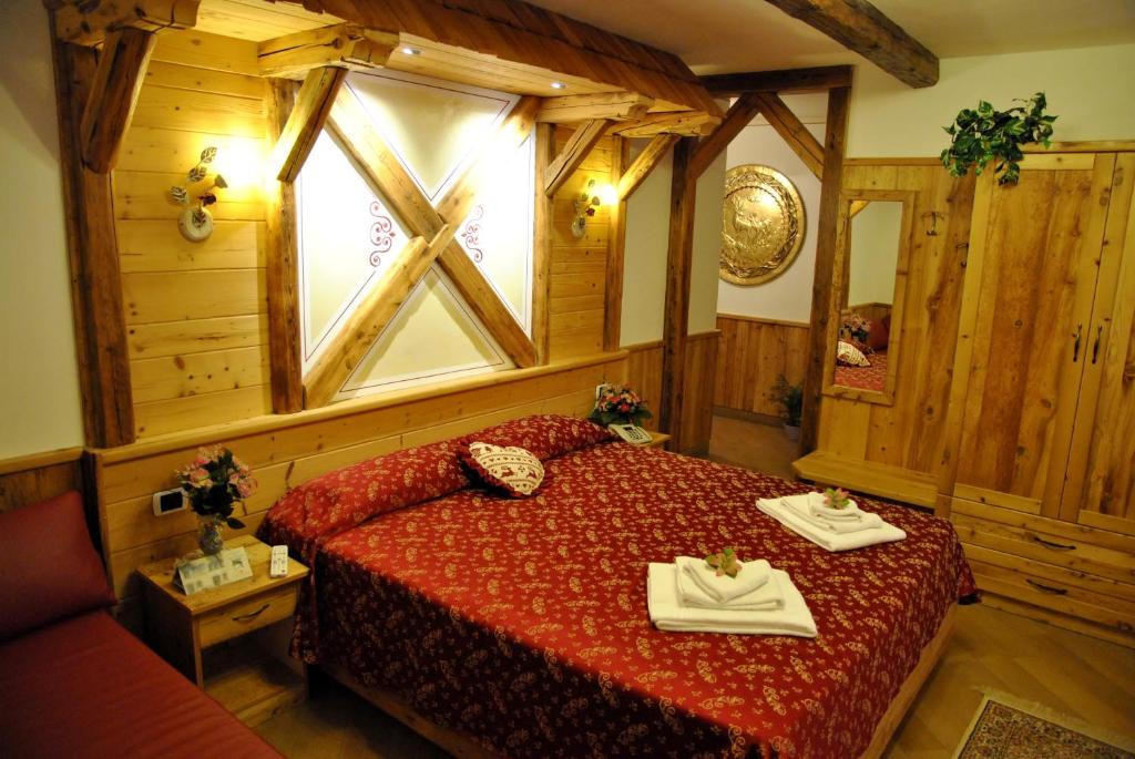 圣洛伦佐因巴纳莱圣洛林佐酒店的一间卧室配有一张带红色床罩的床和窗户