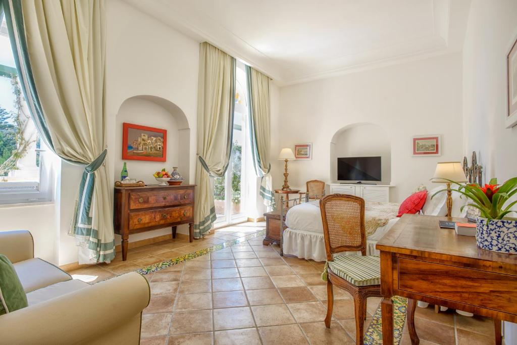 阿纳卡普里西泽奥古斯都酒店的客厅配有沙发和桌子