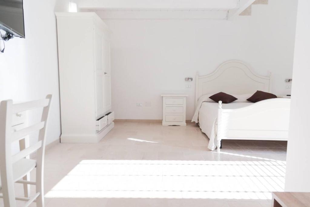 朱尔迪尼亚诺Palazzo Vilei的白色卧室配有床和椅子