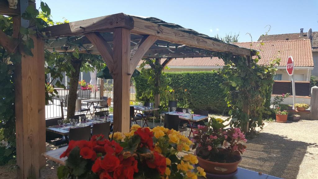 茅尔斯国际之家克吕泽尔酒店的庭院里带桌子和鲜花的木制凉棚