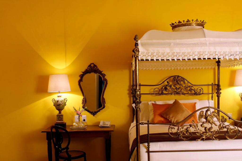 坎佩切Hotel Boutique Casa Don Gustavo, Campeche的一间卧室配有一张床和镜子