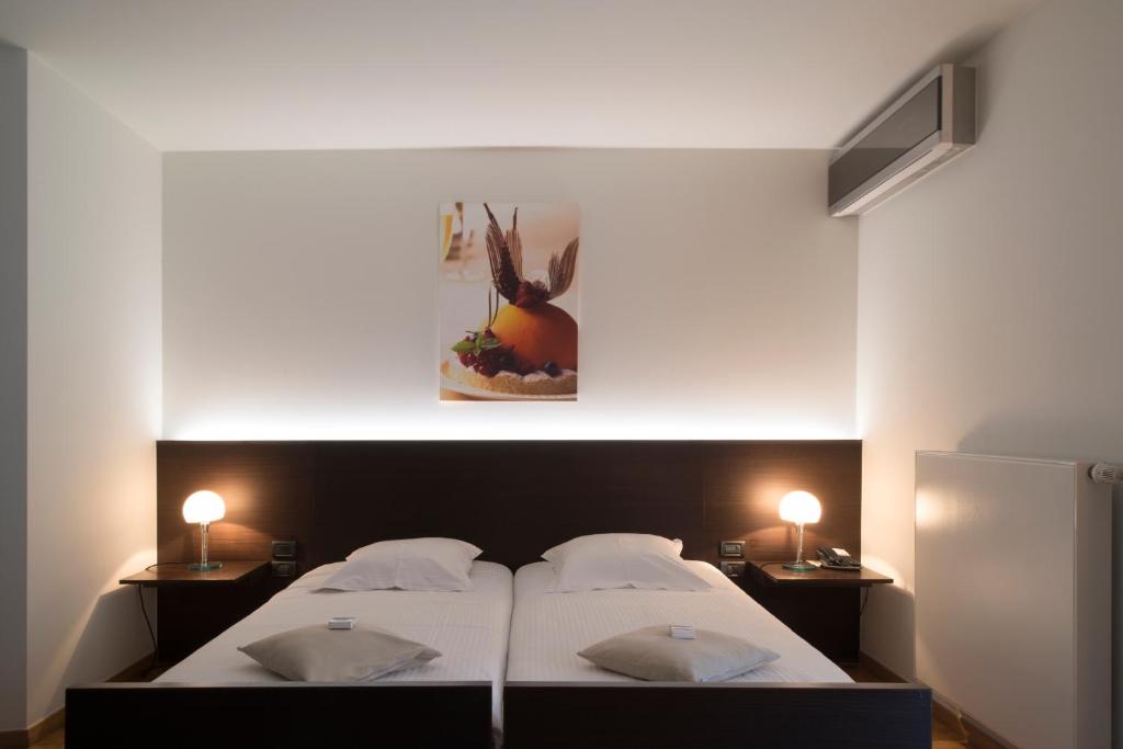 赫尔沃尔卢酒店的一间卧室配有一张带两盏灯的大型白色床。