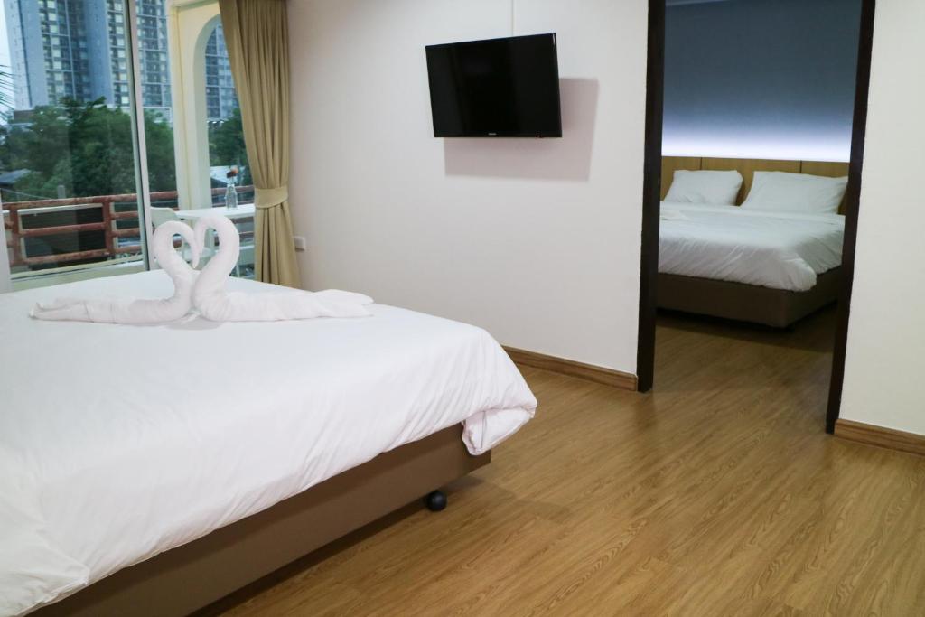 曼谷比尔班酒店的酒店客房,设有两张床和镜子
