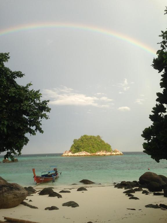 丽贝岛卡塔雷海滩度假Spa酒店的海滩上的彩虹,带椅子和岛屿