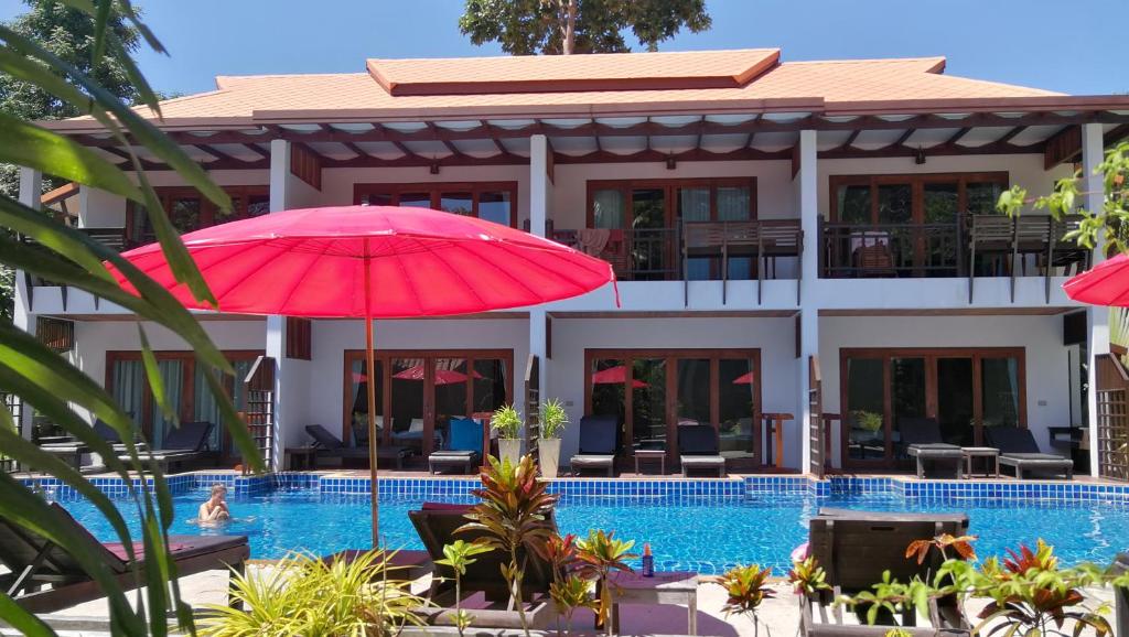 涛岛蓝钻度假酒店的一座设有游泳池和红伞的酒店