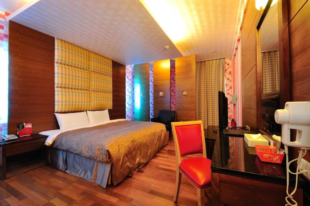Daliao花乡旅馆连锁-大寮店  的一间卧室配有一张床、一张桌子和一把椅子