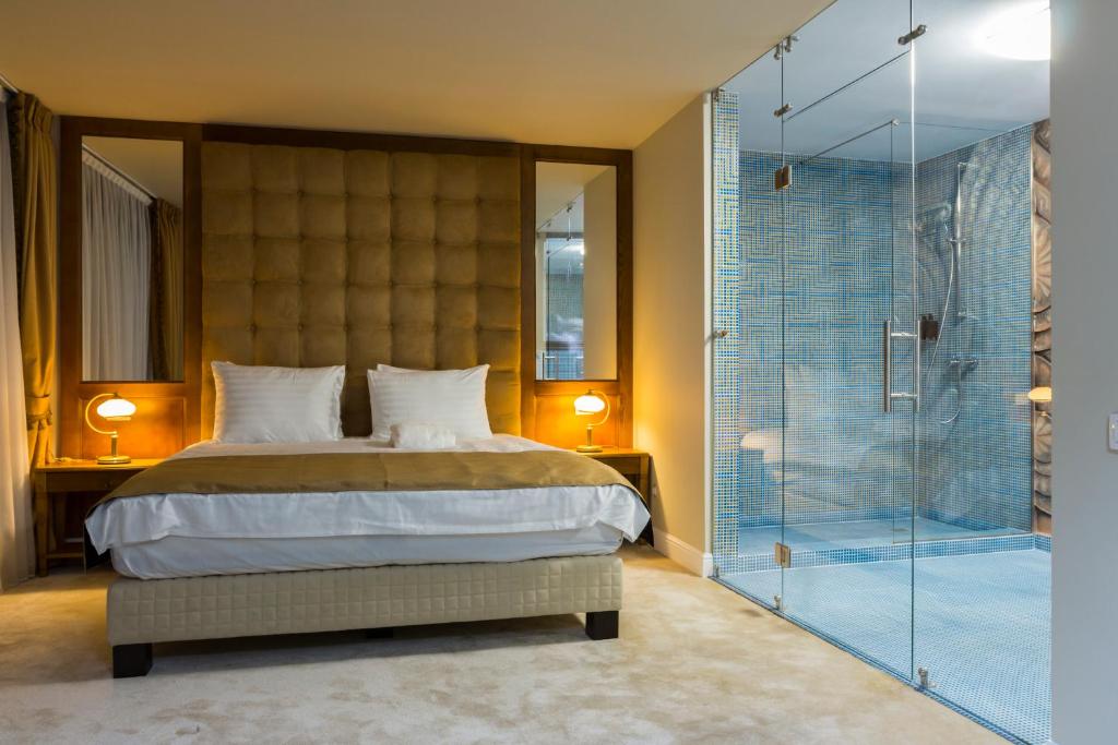 布加勒斯特甘佐精品酒店 的一间卧室设有一张床和一个玻璃淋浴间