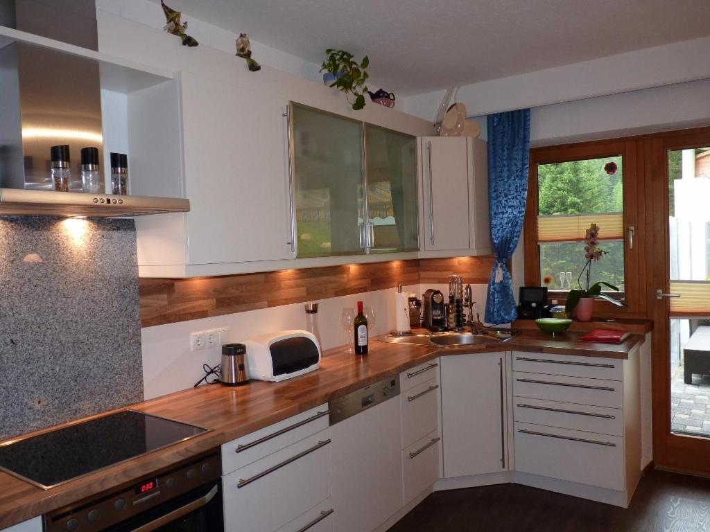索尔登Alpenspirit的厨房配有白色橱柜和木制台面