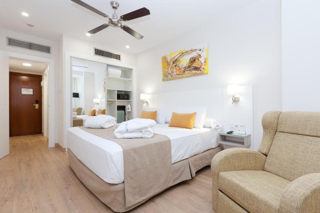 马德里巴拉哈斯参议员酒店的一间卧室配有一张大床和一张沙发
