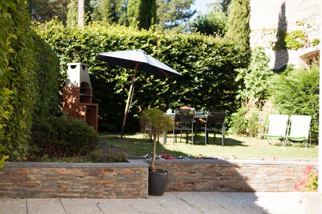 马扎梅La Prade des "Pierre"的花园配有遮阳伞和桌椅