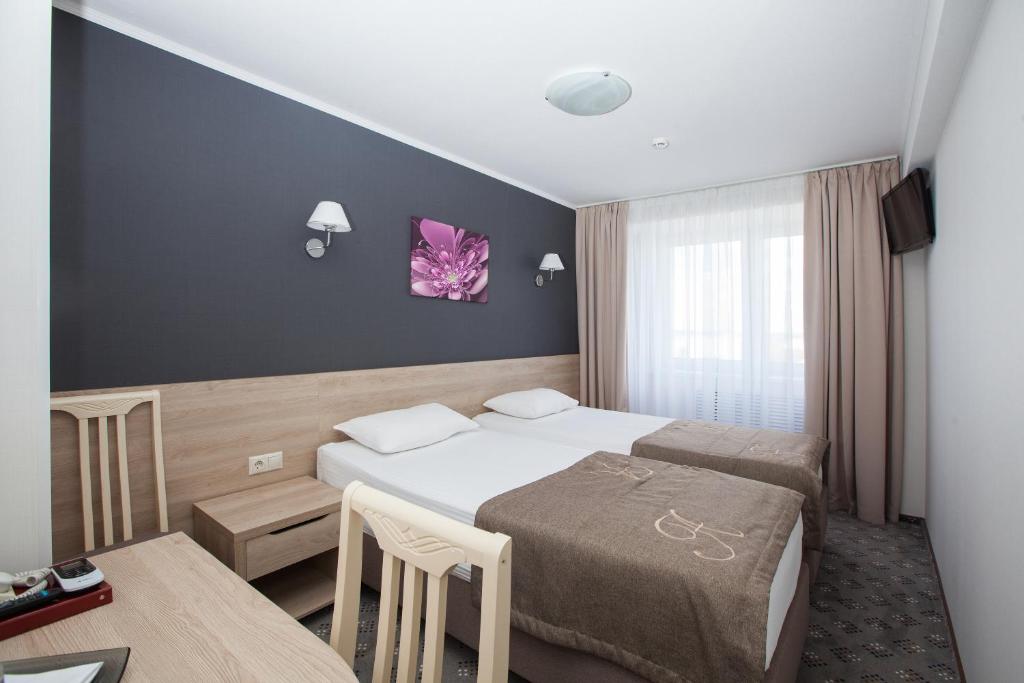 弗拉基米尔阿马克思左洛托科特索酒店 的酒店客房设有两张床和一张桌子。