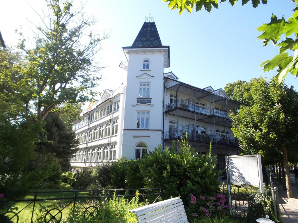 宾茨Villa Stranddistel的一座白色的大建筑,设有钟楼