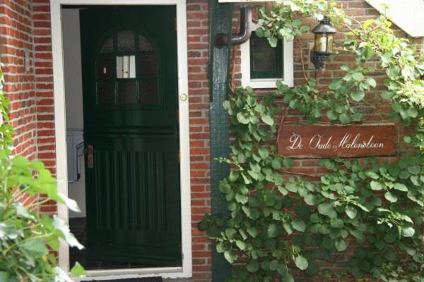 伊尔德帕特斯伍德B&B De Oude Molensteen的砖屋,有绿门和标志