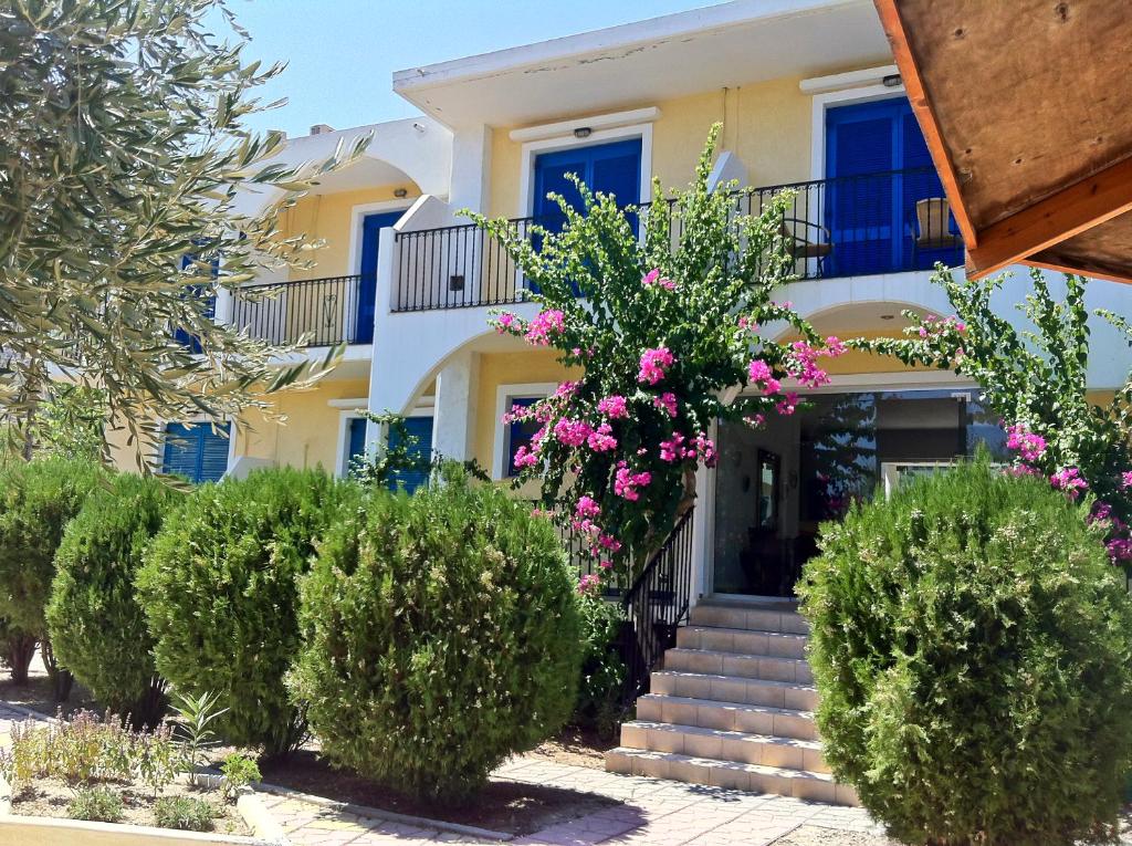 里瓦的亚Castellania Hotel Apartments的前面有楼梯和鲜花的房子